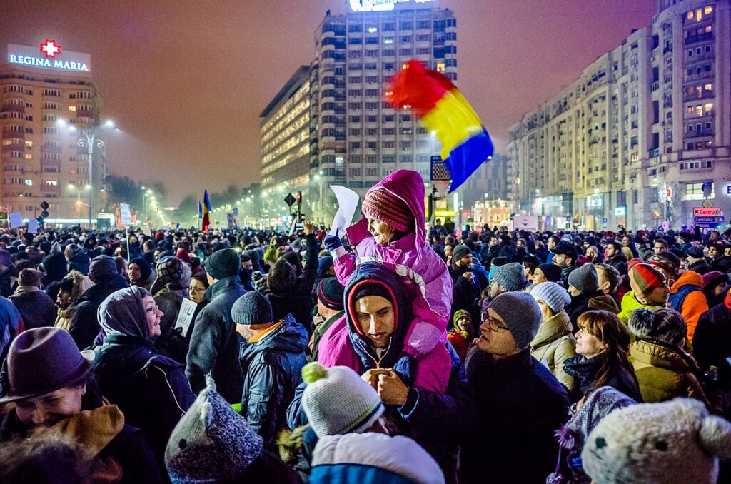 Susținătorii lui Bolojan sunt chemați ȋn Piața Victoriei. Manifestație anunțată pe Facebook pentru luni seara